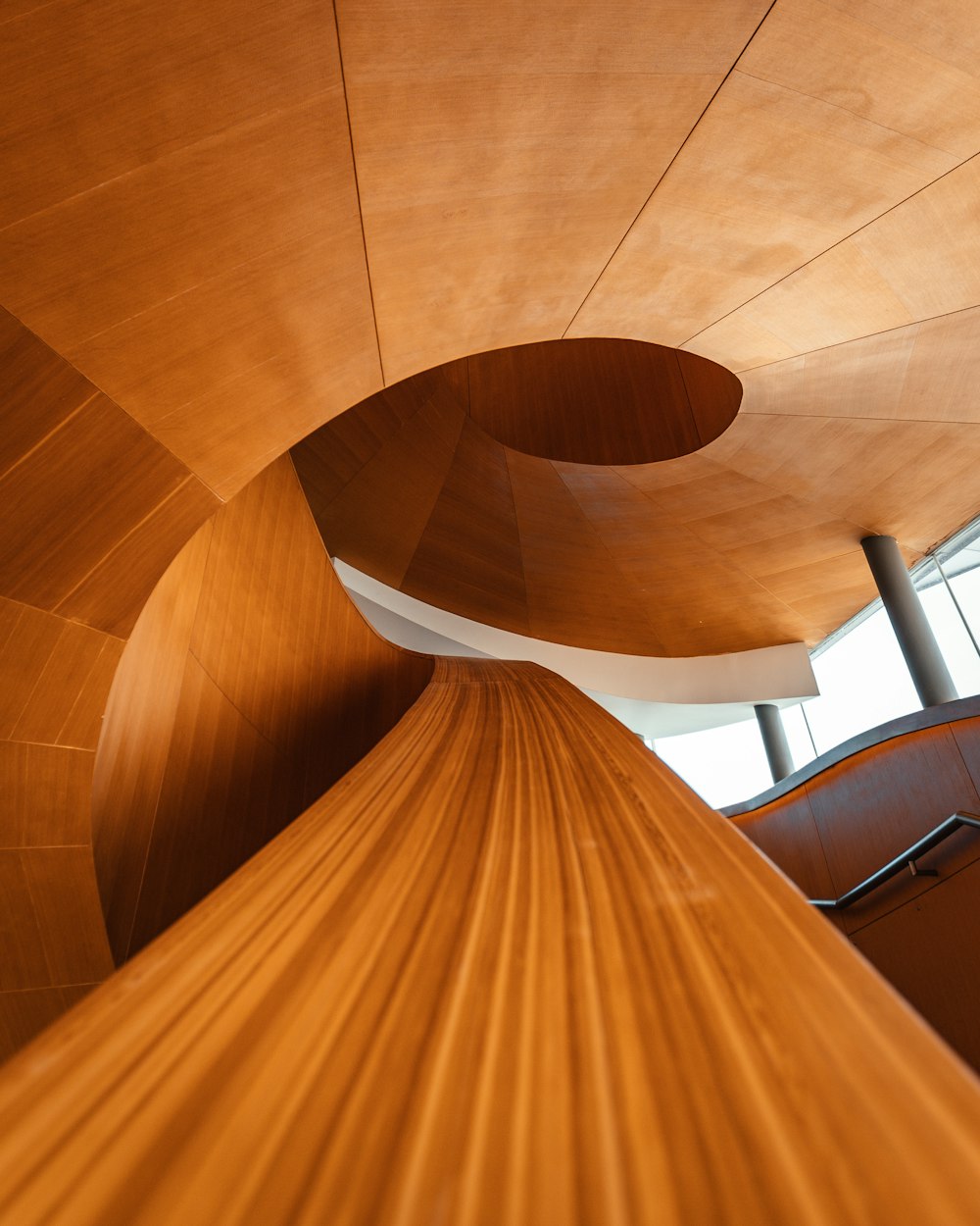 Escalera de caracol de madera marrón con marco de madera blanca