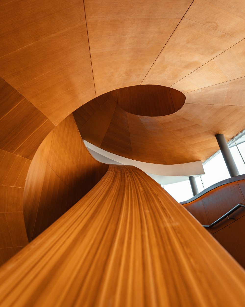 escada em espiral de madeira marrom com estrutura de madeira branca