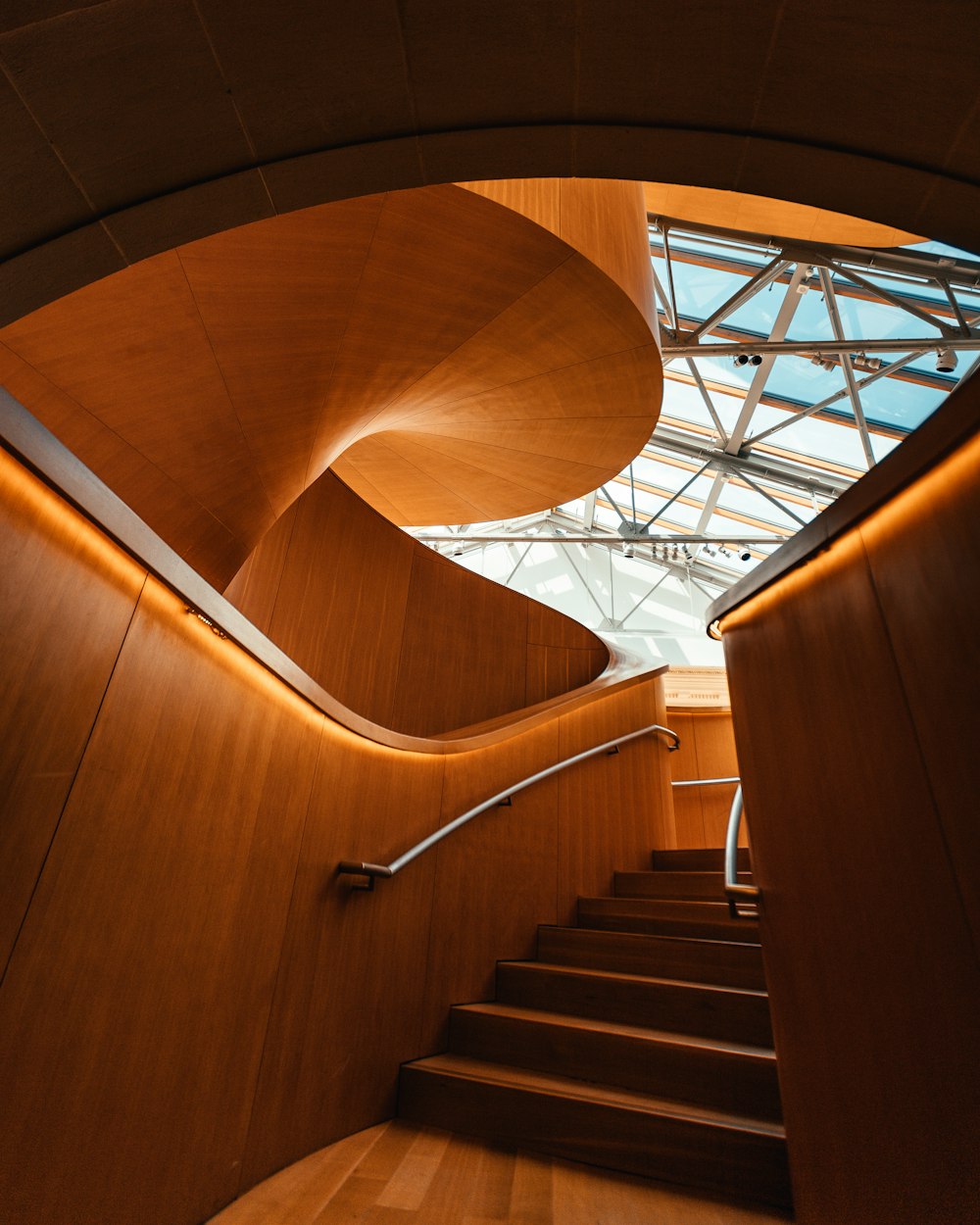 brown wooden spiral staircase with stainless steel railings