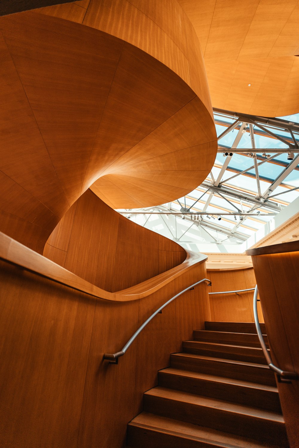 brown wooden spiral staircase with stainless steel railings