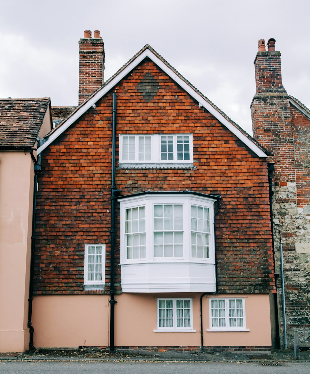 brown brick house with white wooden windows