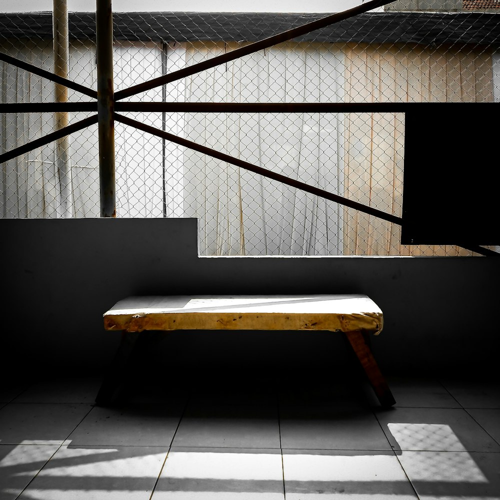 brown wooden bench on white floor tiles