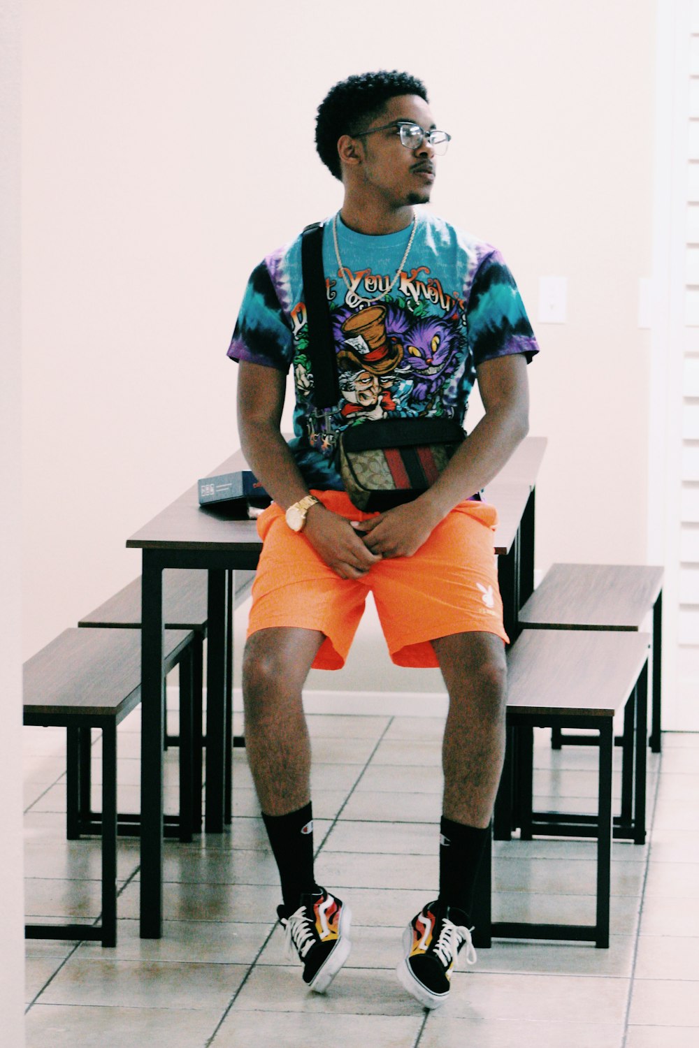 man in blue and white crew neck t-shirt sitting on black wooden table