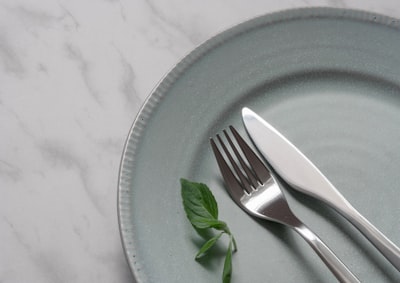 silver fork on blue round plate dish zoom background