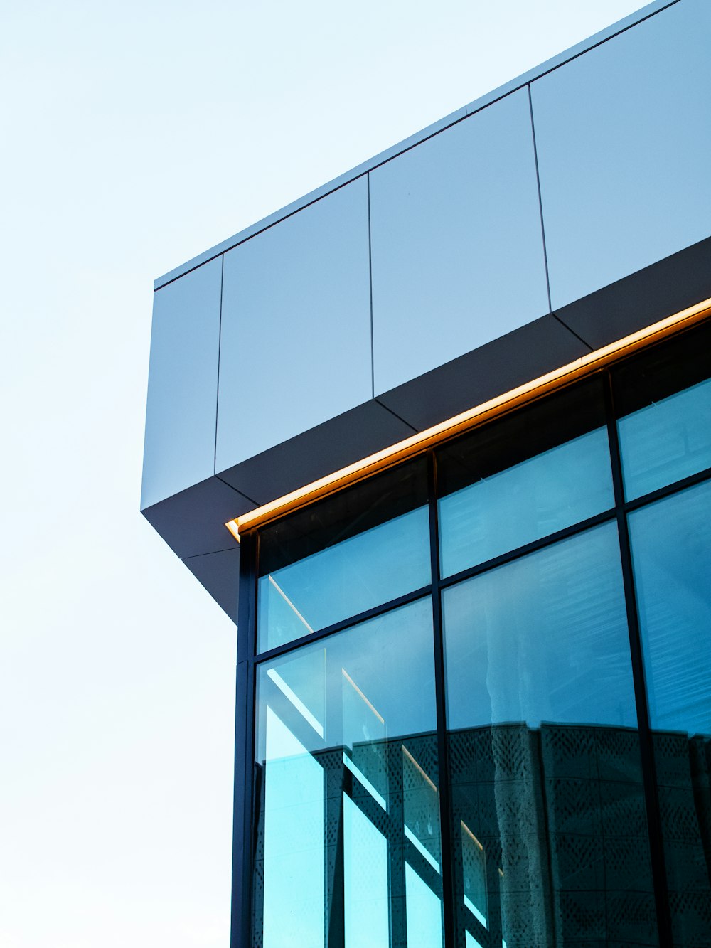 Un primo piano di un edificio di vetro con uno sfondo del cielo