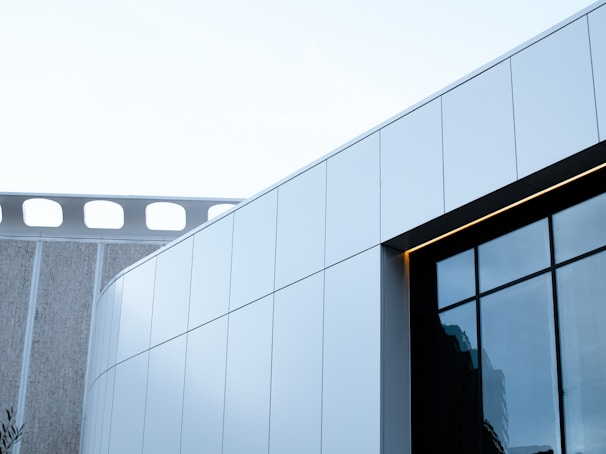 An architectural shot of a sleek, modern facade in deep structure black framing large glass windows.