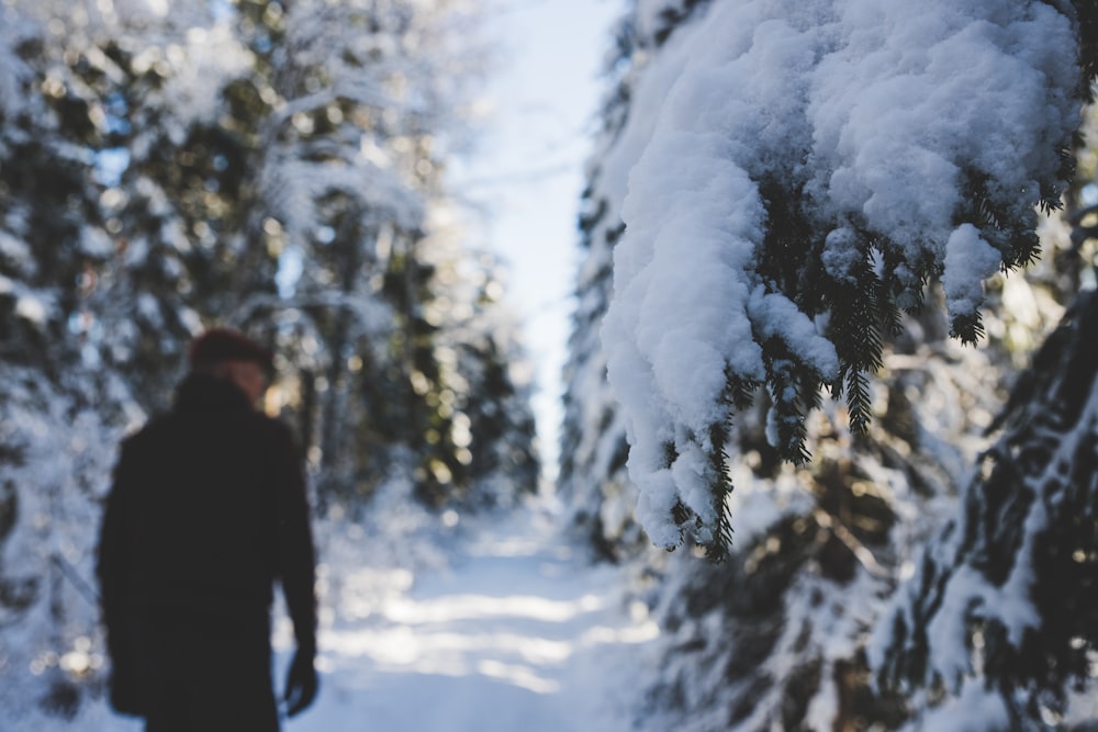 man in black jacket standing on snow covered ground during daytime