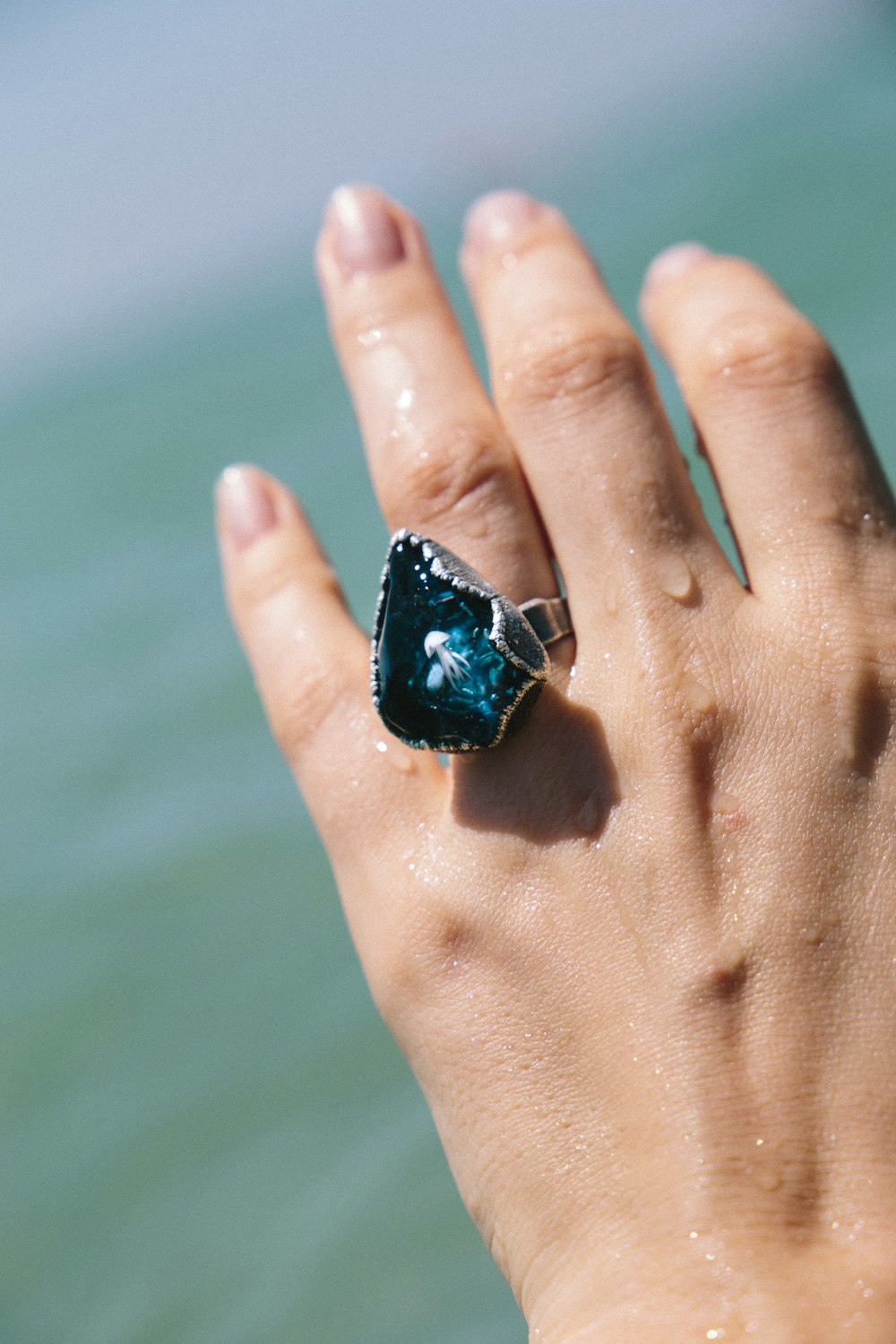 blue and black stone on persons hand