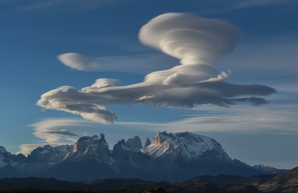 white clouds over snow covered mountains