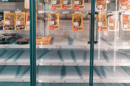 A frustrated business owner looking at empty store shelves.