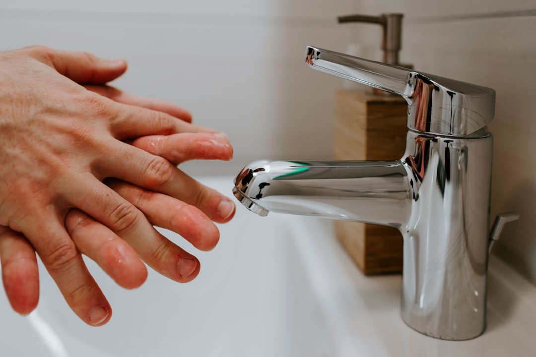 person holding stainless steel faucet