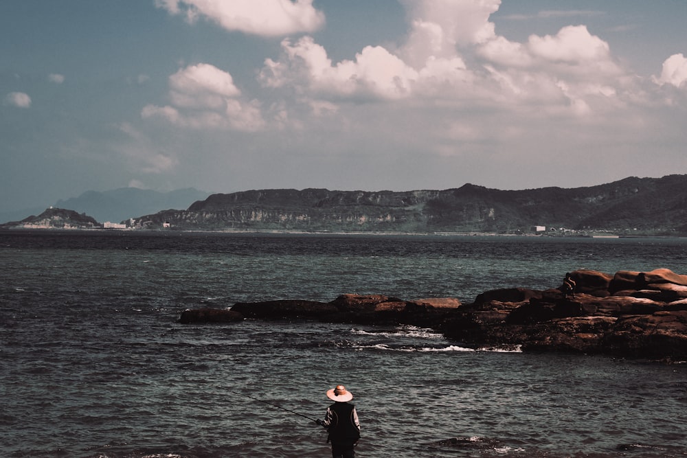 a man standing in the water looking at the ocean