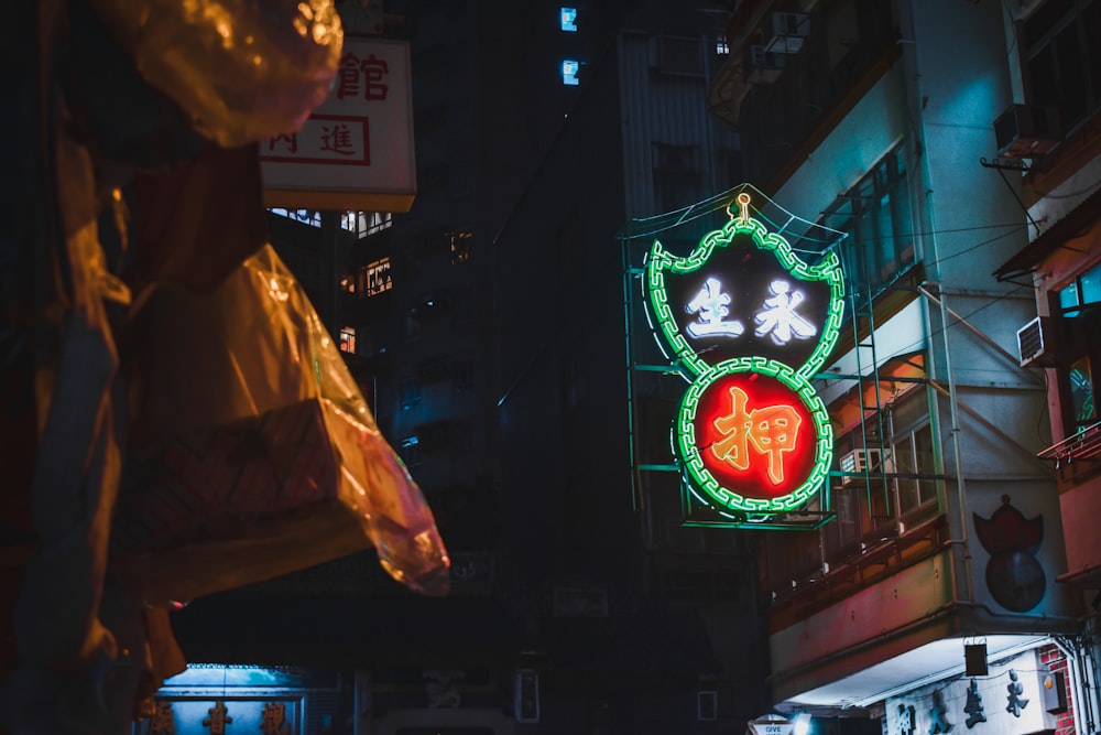 man in white dress shirt standing near red and green lighted signage