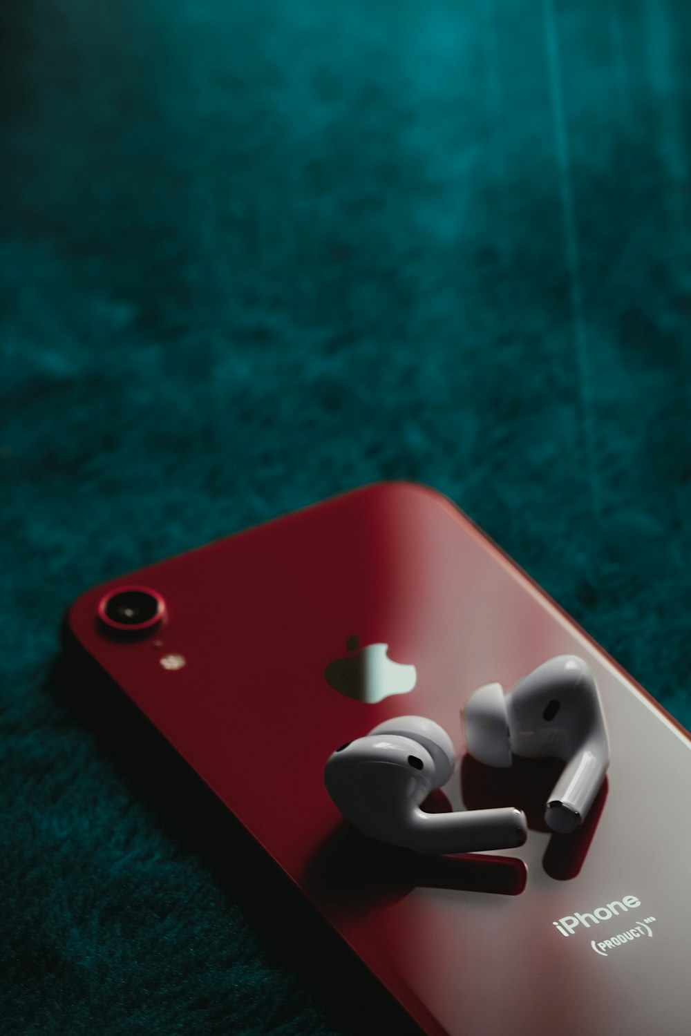 white earbuds on red iphone case