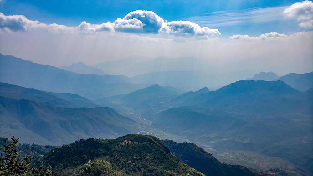 Montañas verdes bajo nubes blancas durante el día