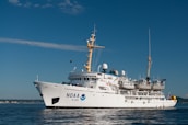 white and blue ship on sea under blue sky during daytime
