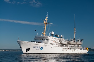 white and blue ship on sea under blue sky during daytime