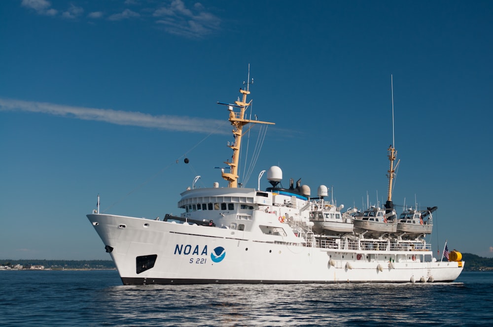 white and blue ship on sea under blue sky during daytime