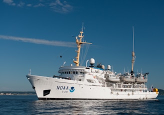 white and blue ship on sea under blue sky during daytime