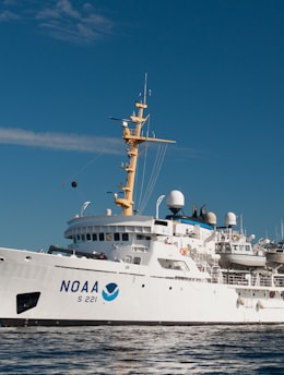 white and blue ship on sea under blue sky during daytime