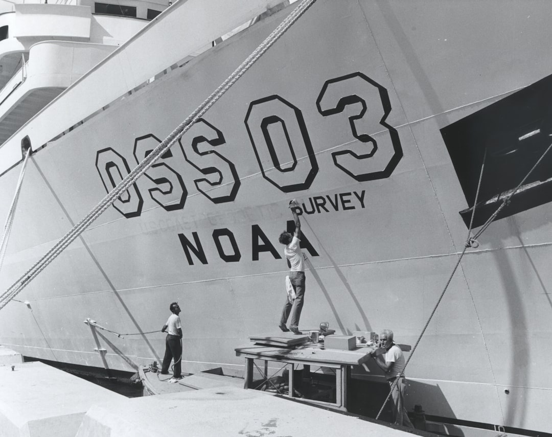 man in white shirt and blue denim jeans standing on white ship