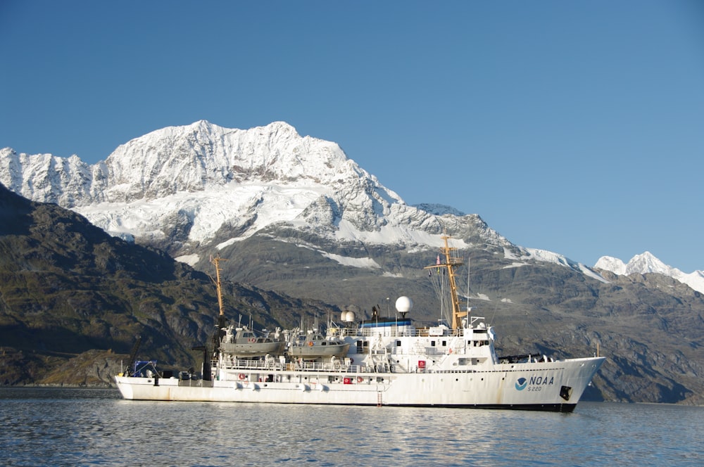 white ship on sea near snow covered mountain during daytime