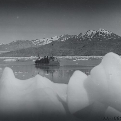 snow covered mountain near body of water during daytime