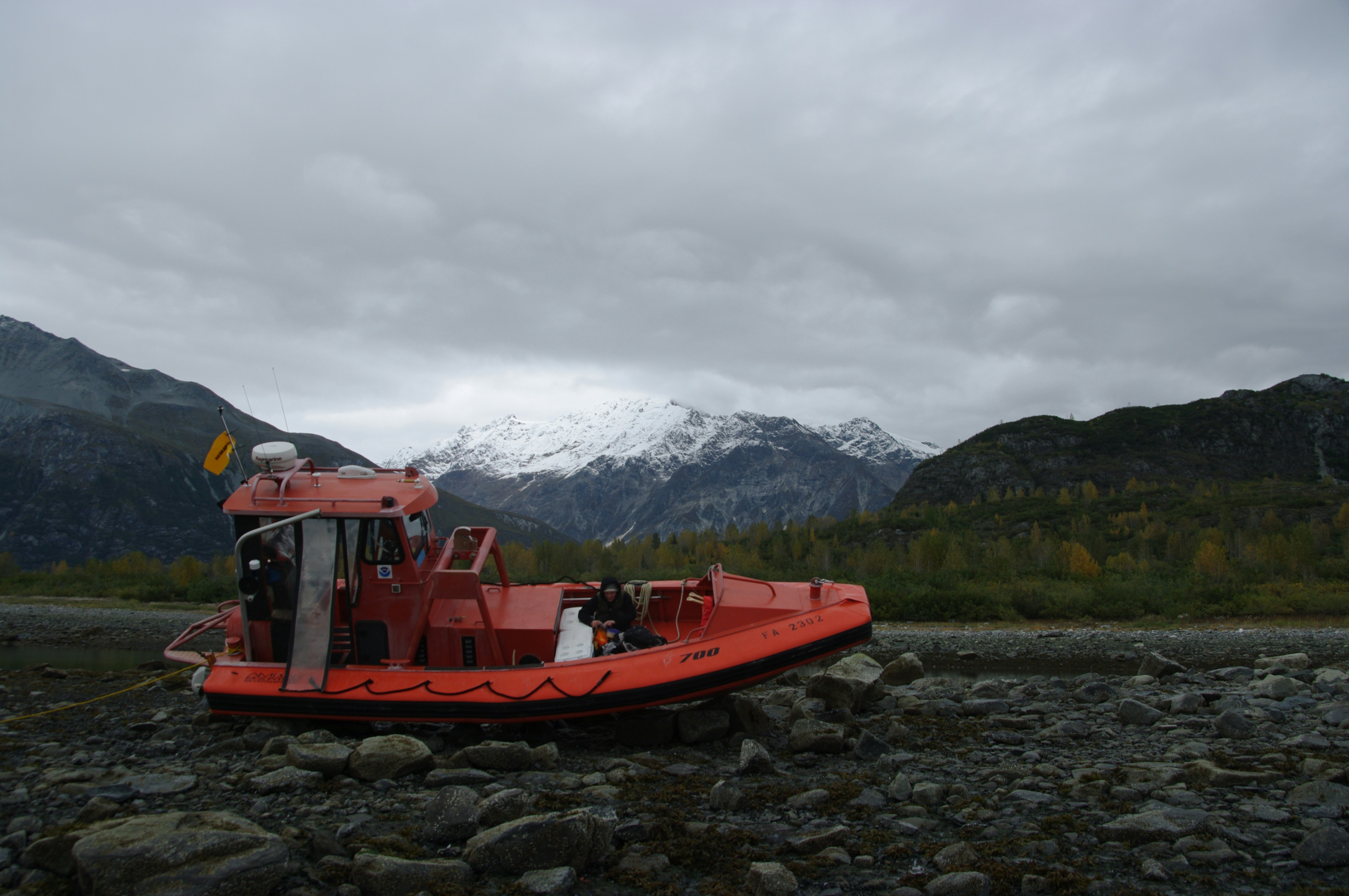 red boat on body of water near mountain during daytime