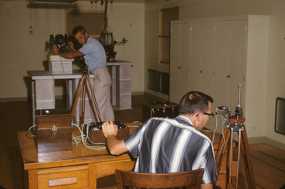 man in gray and blue stripe polo shirt sitting on chair