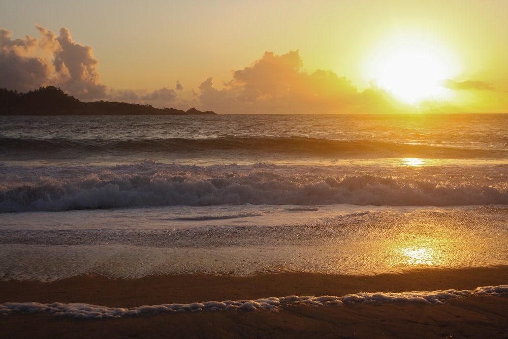 ocean waves crashing on shore during sunset