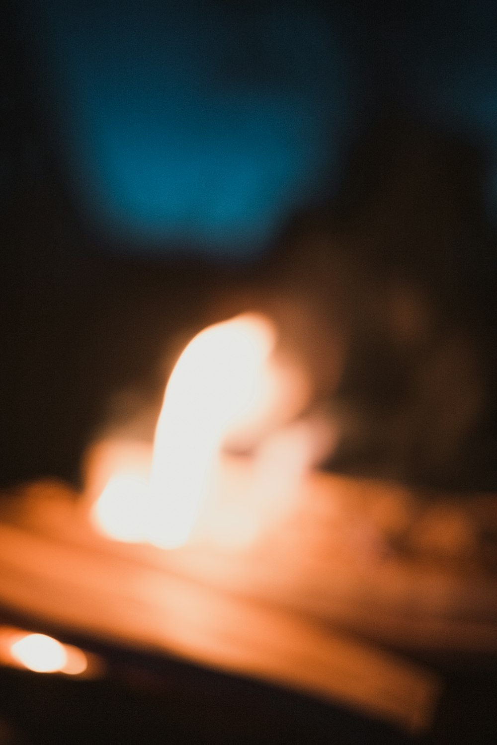 a blurry photo of a lit candle on a table