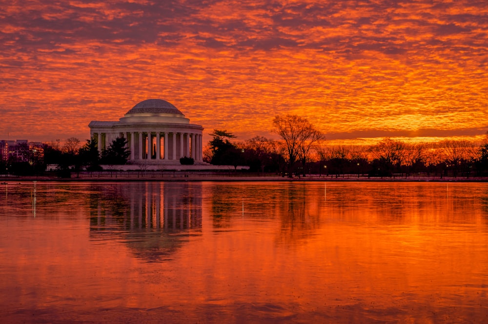 white and brown dome building near body of water during sunset