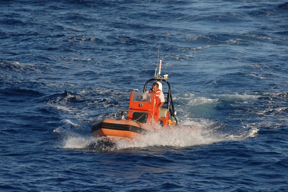 orange and white boat on sea during daytime