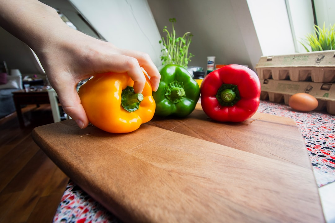 person holding yellow and red bell peppers