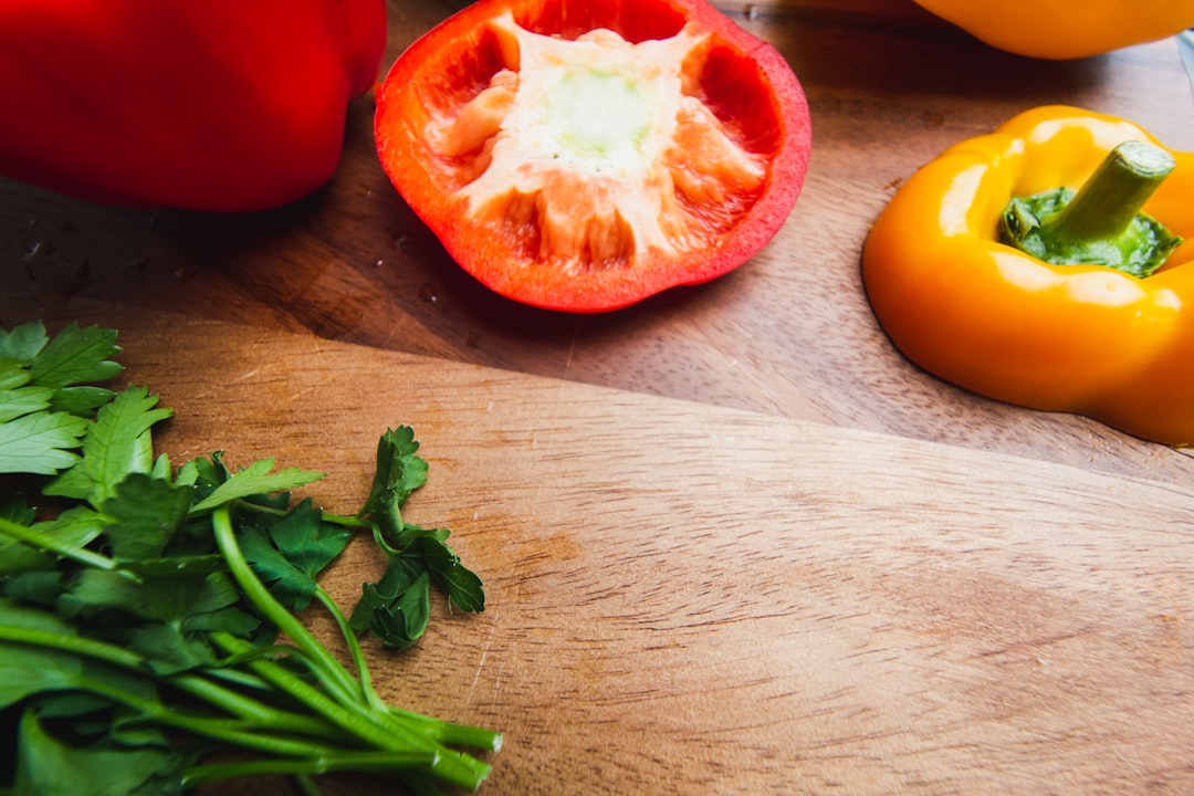 sliced tomato beside green vegetable on brown wooden table