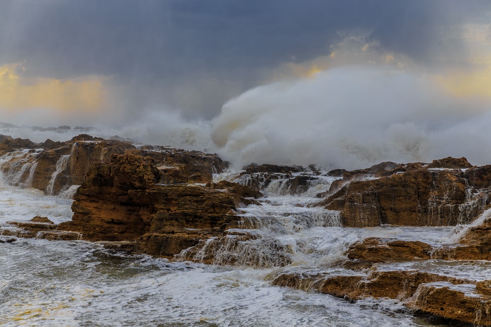 brown rock formation near body of water during daytime