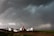 A candid shot of volunteers loading vehicles with supplies under a cloudy sky.