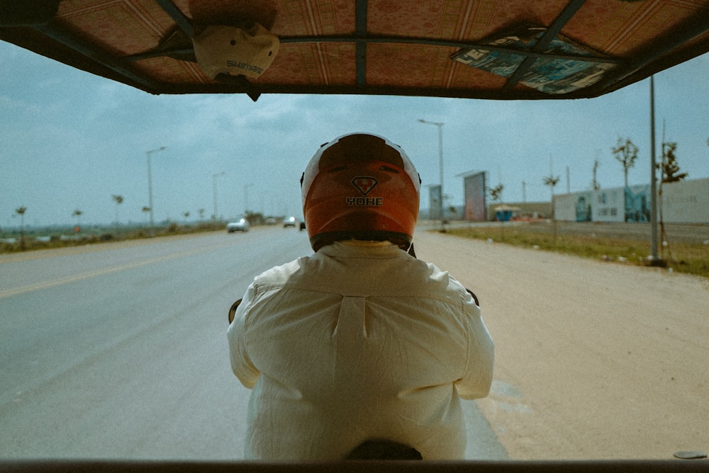 a person sitting in the back of a vehicle on a road