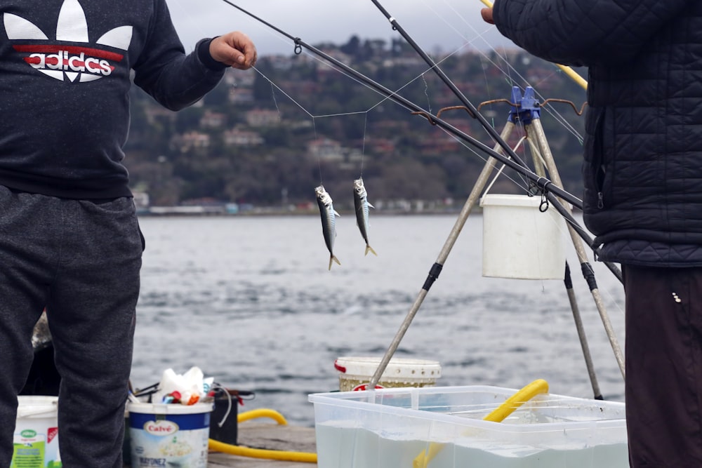 persona che tiene la canna da pesca e il pesce