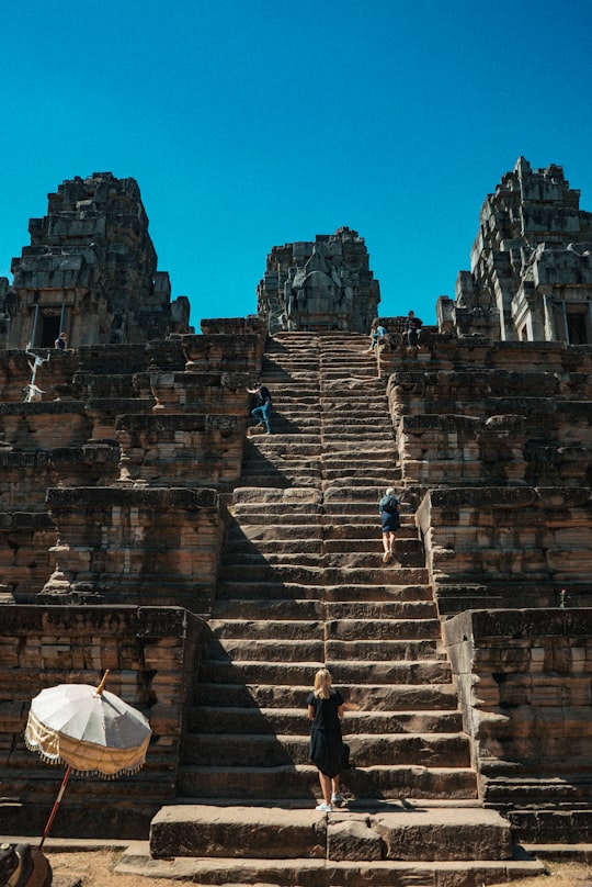 man in black jacket standing on stairs in Angkor Thom Cambodia