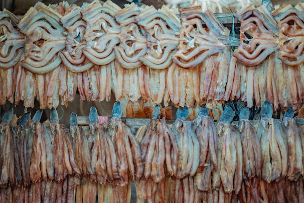 Close-up of neatly arranged clean dry fish on a rustic wooden surface.
