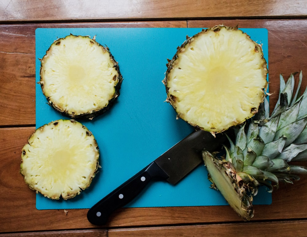 sliced pineapple fruit beside black handled knife