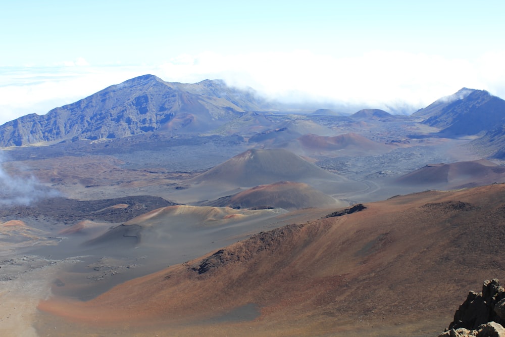 brown and green mountains under white clouds during daytime