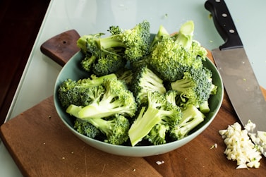 green broccoli on brown wooden chopping board