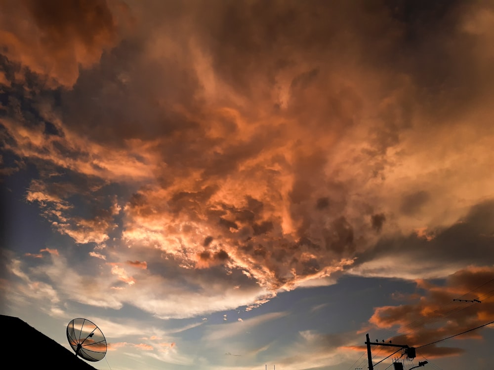 basketball hoop under cloudy sky during sunset