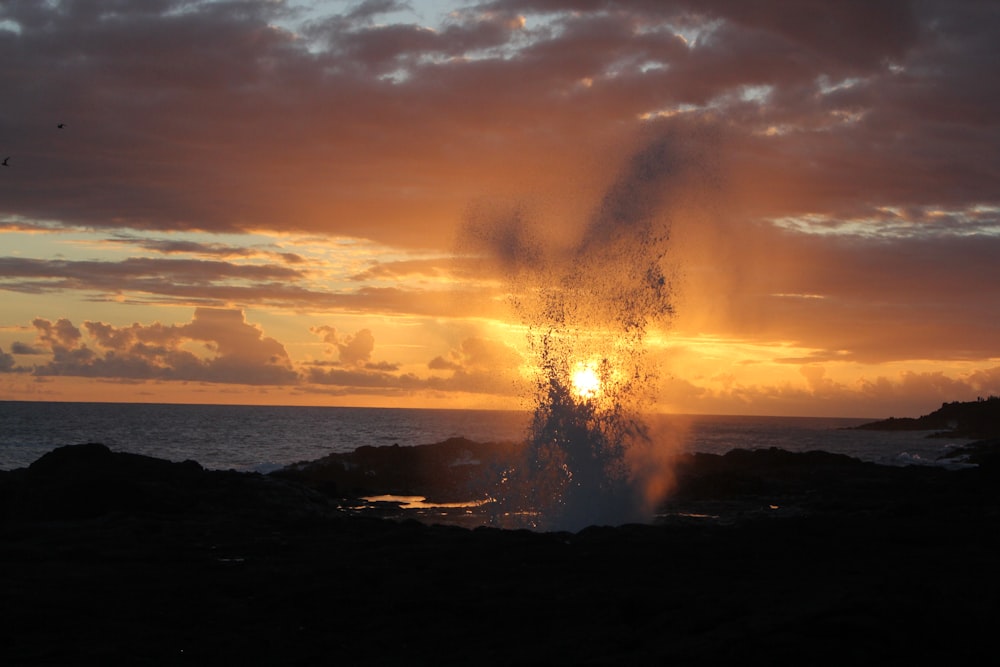 sea waves crashing on shore during sunset