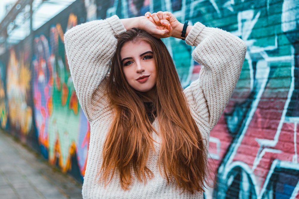 a woman standing in front of a graffiti wall