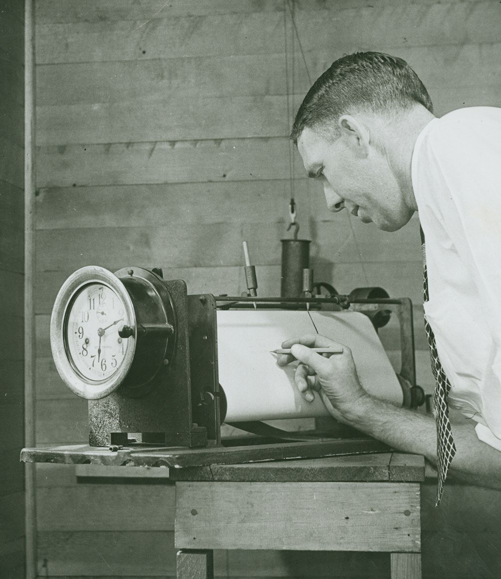 man in white shirt holding a gray machine