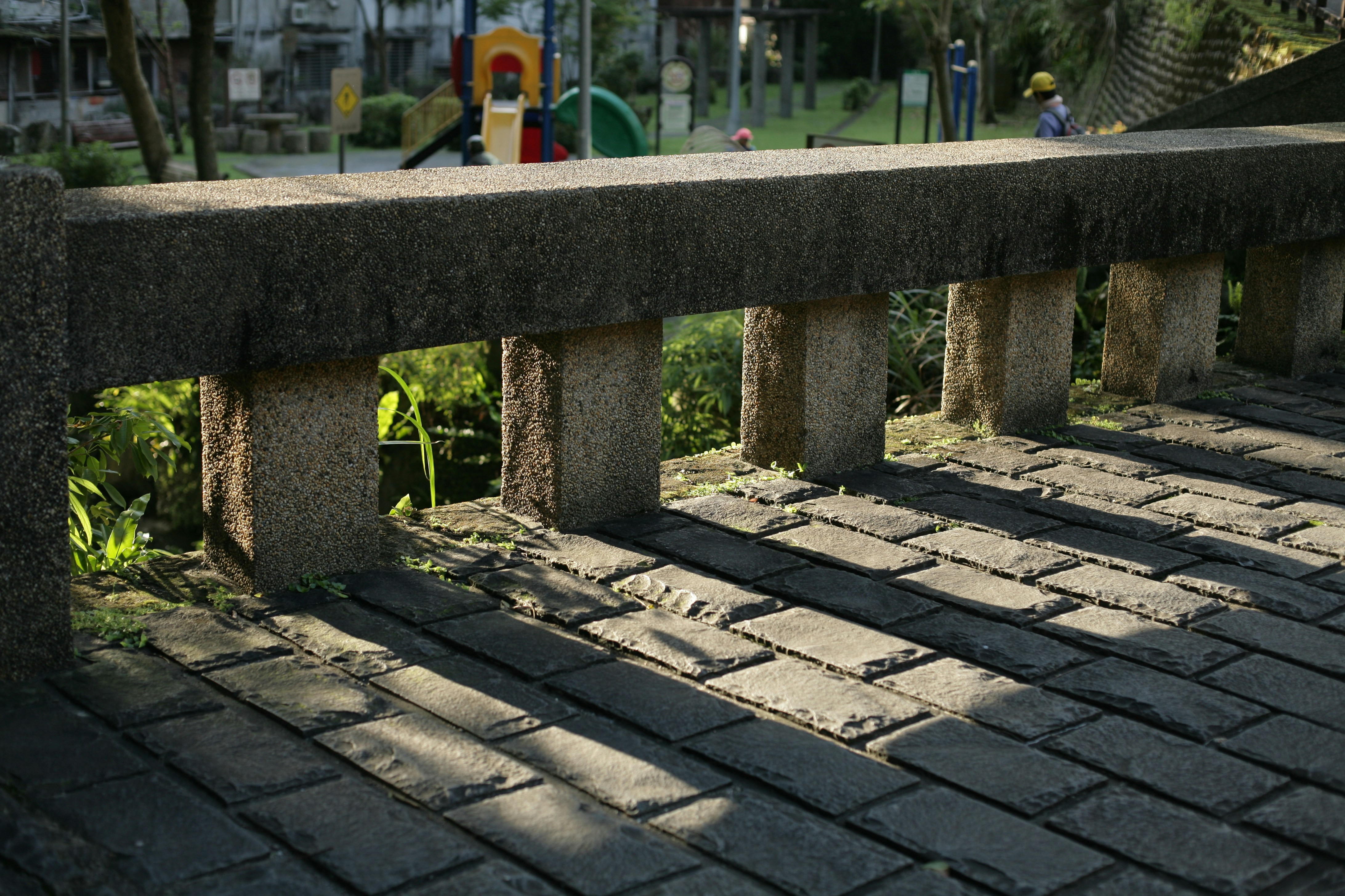 brown concrete bench near green trees during daytime