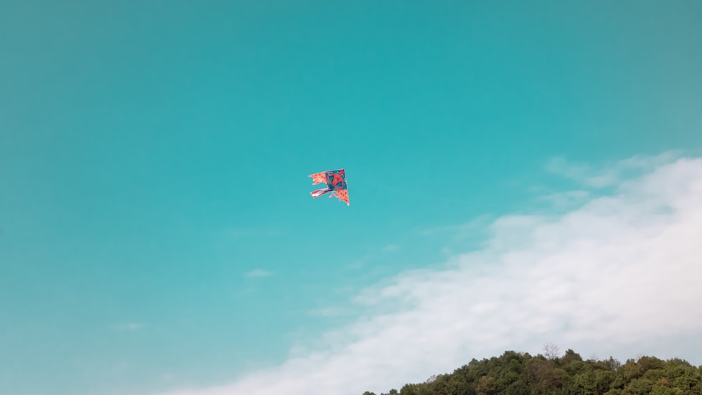 a person flying a kite in a blue sky